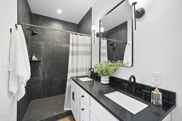 full bathroom with tiled shower, double vanity, and recessed lighting