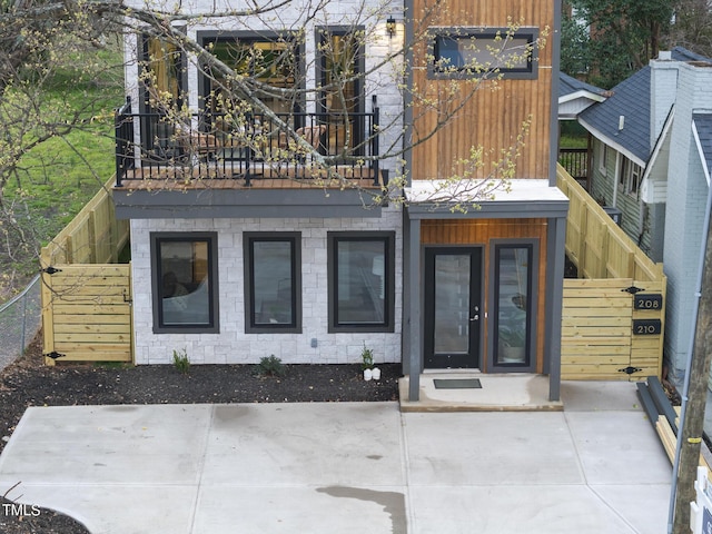 back of house with a balcony and fence