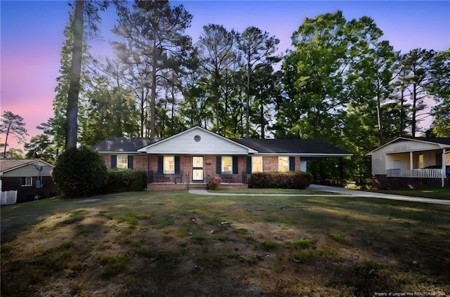 view of front of house featuring a yard and brick siding