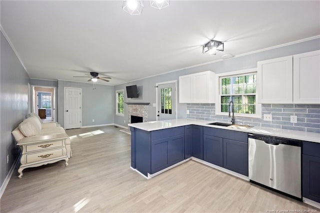 kitchen with dishwasher, ceiling fan, a sink, a peninsula, and crown molding