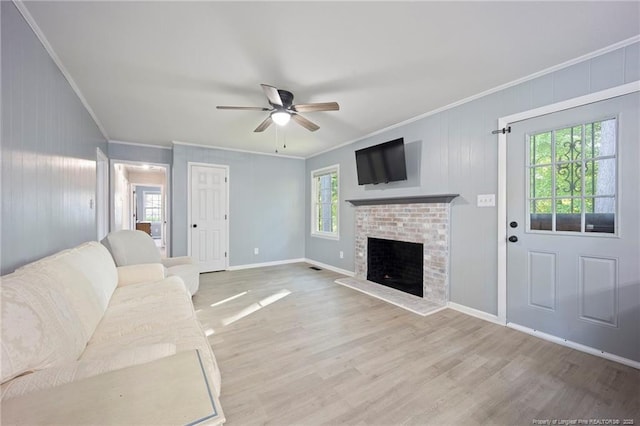 unfurnished living room with crown molding, a brick fireplace, wood finished floors, and ceiling fan