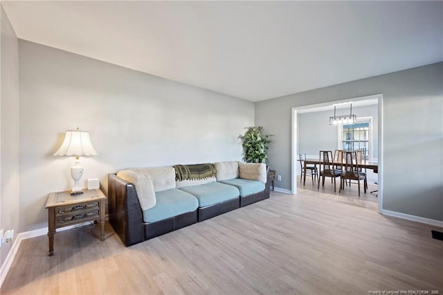 living area with visible vents, wood finished floors, and baseboards