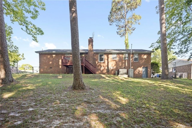 back of property with a chimney, a yard, stairway, and brick siding