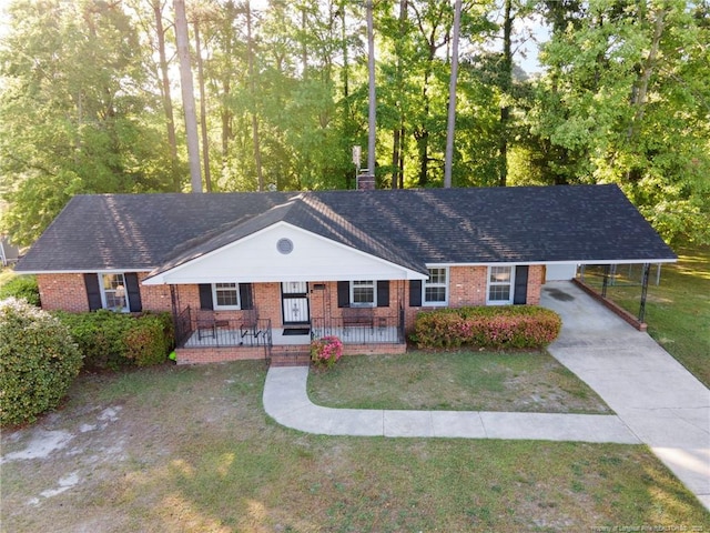 ranch-style house featuring covered porch, concrete driveway, a front lawn, and brick siding
