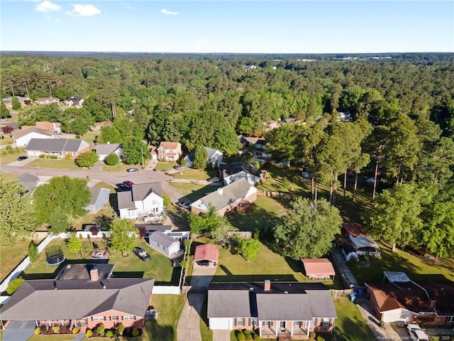 drone / aerial view with a wooded view and a residential view
