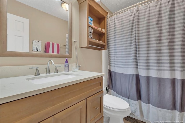 bathroom featuring toilet, a shower with shower curtain, vanity, and a textured ceiling