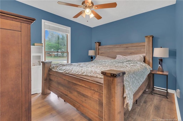 bedroom with wood finished floors, baseboards, and ceiling fan