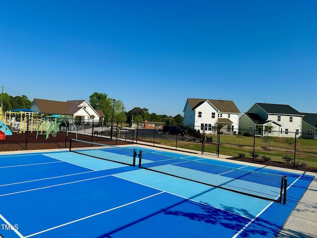 view of sport court featuring fence, community basketball court, and a residential view
