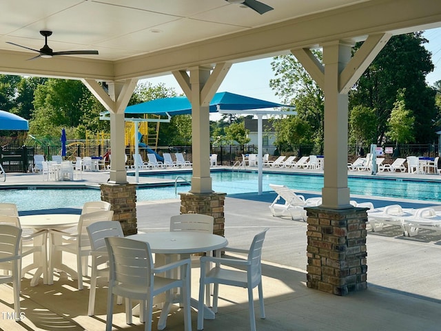 pool featuring playground community, a patio, fence, and ceiling fan