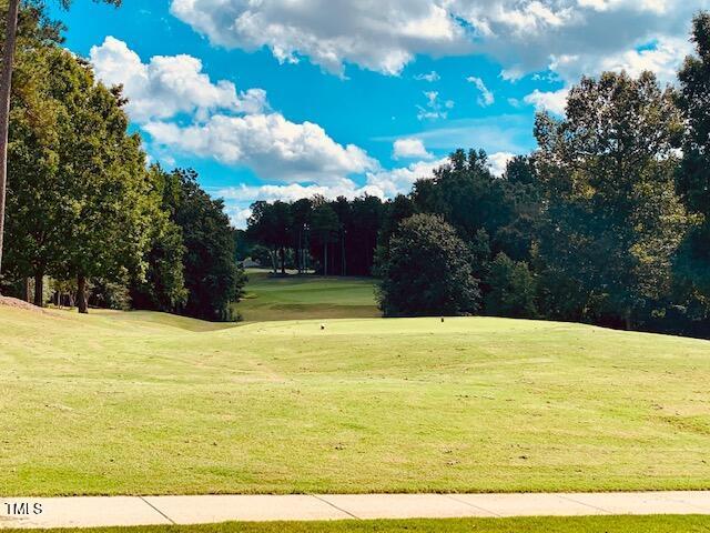 surrounding community with a yard and view of golf course