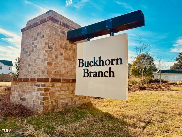 community / neighborhood sign featuring a yard