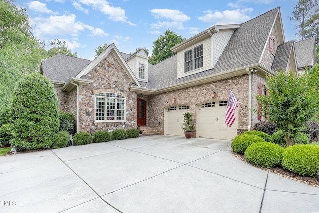 view of front of house featuring driveway, roof with shingles, and stone siding