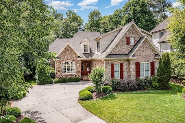 view of front of house with a front yard, brick siding, and a shingled roof