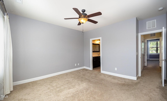 unfurnished bedroom with light carpet, baseboards, connected bathroom, and ceiling fan
