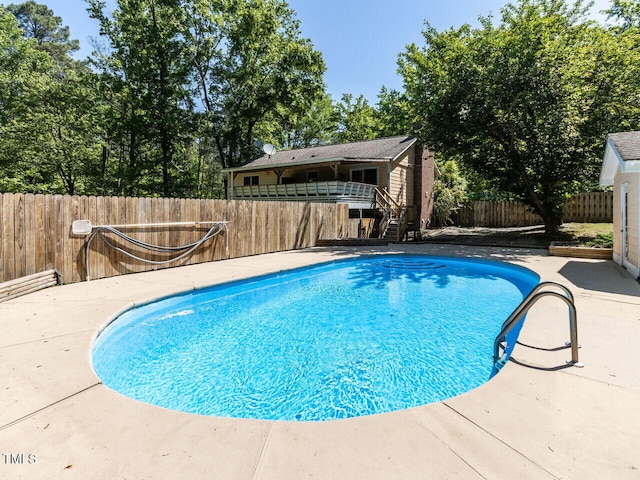 view of pool featuring stairway, a fenced backyard, and a patio