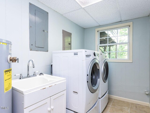 laundry room with electric panel, independent washer and dryer, and water heater