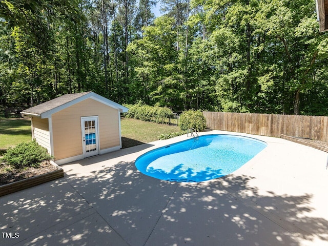 view of swimming pool with a patio area, an outdoor structure, and a fenced backyard