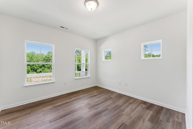 spare room with wood finished floors and baseboards
