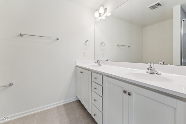 full bathroom featuring double vanity, tile patterned floors, and baseboards