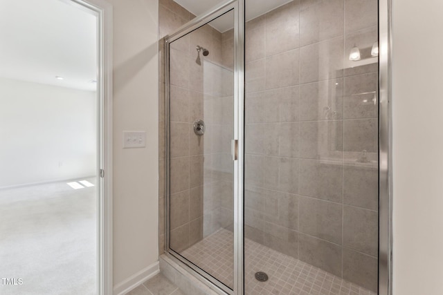 full bath with a shower stall, tile patterned floors, and baseboards