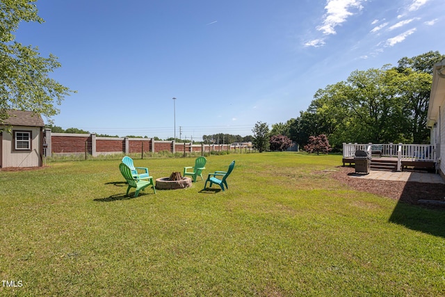 view of yard with an outdoor fire pit, a wooden deck, and an outbuilding