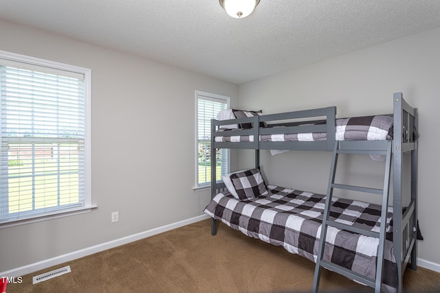 carpeted bedroom with baseboards and a textured ceiling