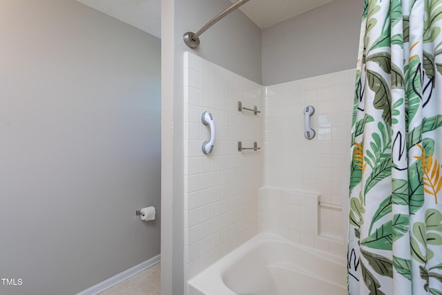 bathroom featuring shower / tub combo with curtain and baseboards
