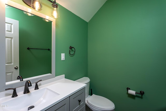 half bath featuring lofted ceiling, toilet, and vanity