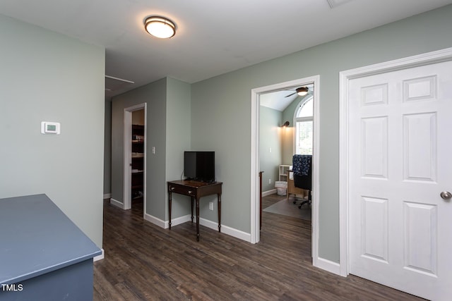 interior space with an office area, dark wood-style flooring, attic access, lofted ceiling, and baseboards