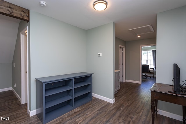 hallway with dark wood-type flooring, baseboards, and attic access