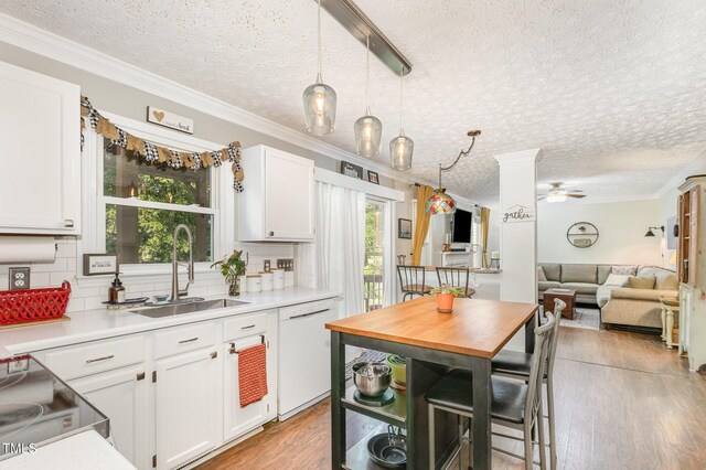 kitchen with dishwasher, a sink, a textured ceiling, a ceiling fan, and tasteful backsplash