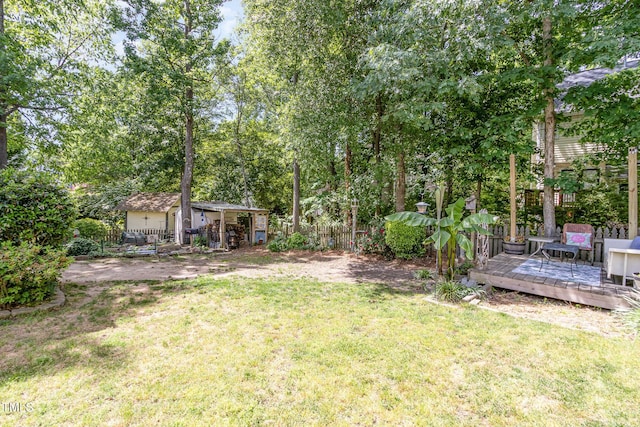 view of yard featuring a deck and an outdoor structure