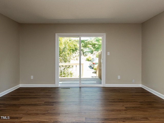 unfurnished room with dark wood finished floors and baseboards