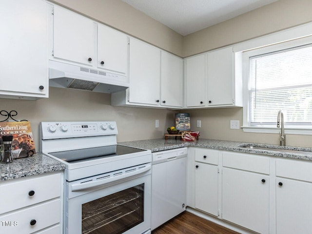 kitchen featuring white appliances, under cabinet range hood, a sink, and white cabinetry