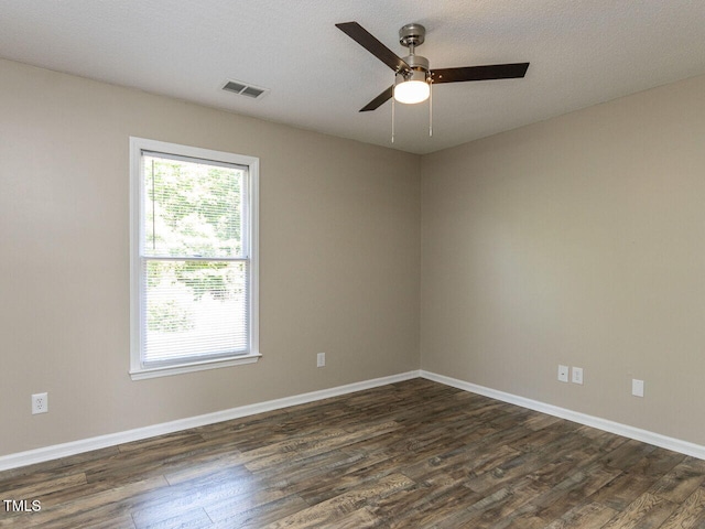 empty room with dark wood finished floors, ceiling fan, and baseboards