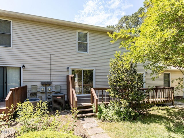 rear view of property featuring a deck and central AC unit