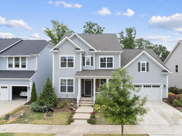 craftsman house featuring concrete driveway, an attached garage, a shingled roof, covered porch, and board and batten siding