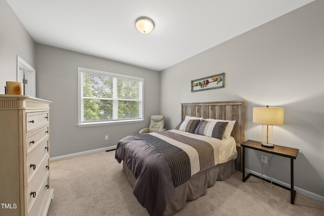 bedroom featuring light colored carpet and baseboards