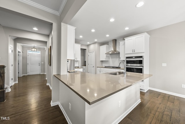 kitchen featuring wall chimney exhaust hood, ornamental molding, appliances with stainless steel finishes, baseboards, and dark wood finished floors