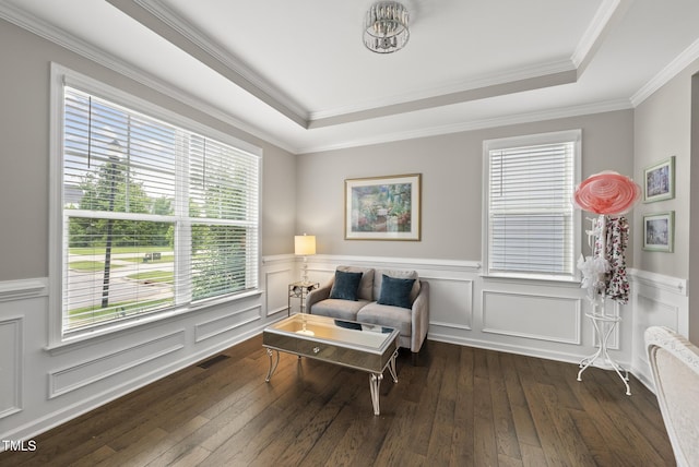 living area featuring a raised ceiling, dark wood finished floors, a wainscoted wall, and crown molding