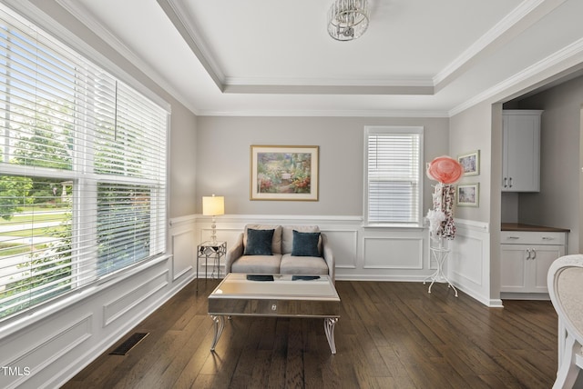 sitting room with a tray ceiling, dark wood-style floors, wainscoting, a chandelier, and ornamental molding