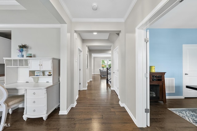 corridor featuring dark wood-type flooring, baseboards, a desk, and crown molding