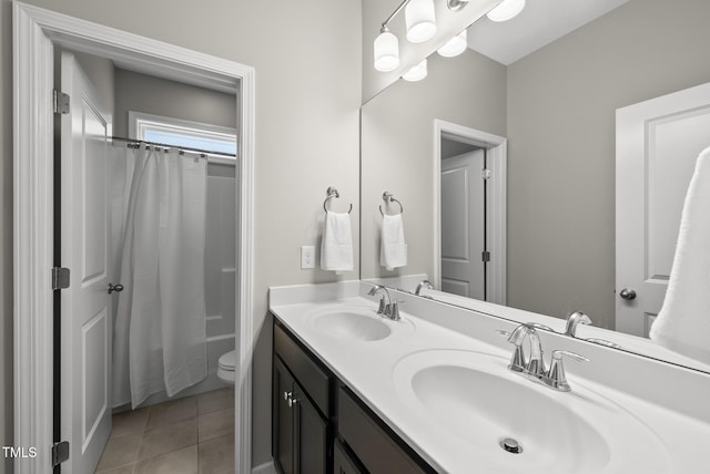bathroom featuring tile patterned flooring, double vanity, and toilet
