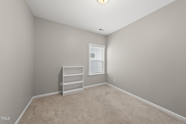 carpeted spare room featuring baseboards