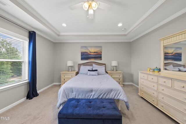 bedroom featuring light colored carpet, multiple windows, ornamental molding, baseboards, and a raised ceiling