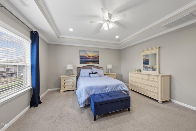 bedroom featuring light carpet, a tray ceiling, ornamental molding, baseboards, and ceiling fan