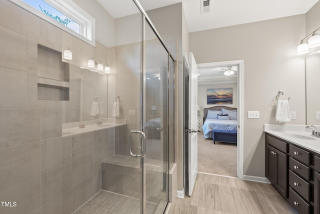 ensuite bathroom with vanity, a stall shower, and a ceiling fan