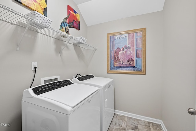 washroom with washing machine and clothes dryer and baseboards