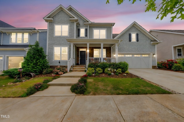 view of front of property featuring covered porch, concrete driveway, and a garage