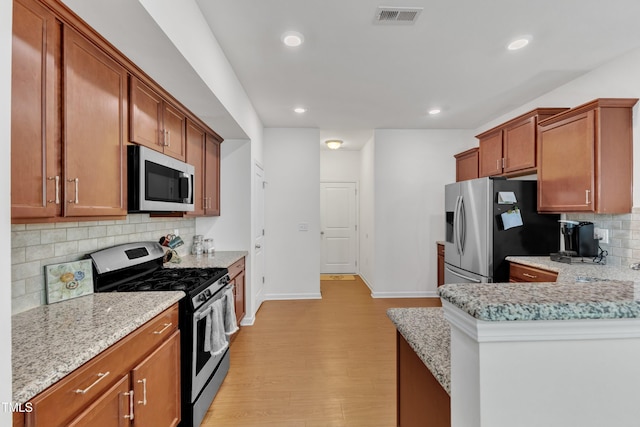 416 Durants Neck Ln, Morrisville, NC 27560 - kitchen with appliances with stainless steel finishes, light wood-style floors, decorative backsplash, baseboards, and recessed lighting